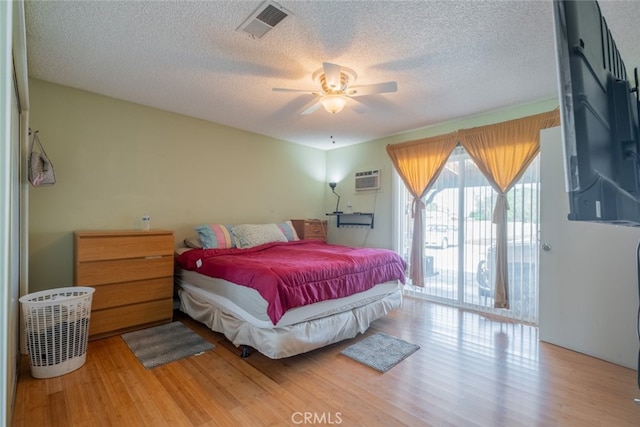 5111 W W Ave M2, Lancaster, CA 93536 - bedroom with a textured ceiling, access to outside, wood finished floors, a ceiling fan, and a wall unit AC