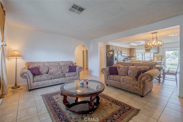 5111 W W Ave M2, Lancaster, CA 93536 - living room featuring arched walkways, light tile patterned floors, and a chandelier