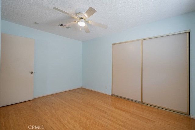 5111 W W Ave M2, Lancaster, CA 93536 - unfurnished bedroom with light wood-style floors, a closet, a ceiling fan, and a textured ceiling