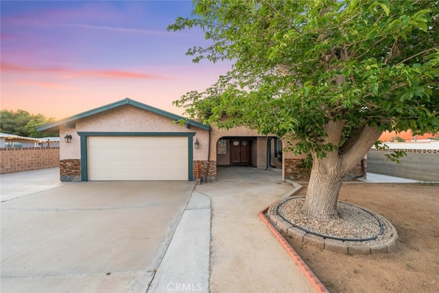 5111 W W Ave M2, Lancaster, CA 93536 - view of front facade with concrete driveway, a garage, stucco siding, and fence