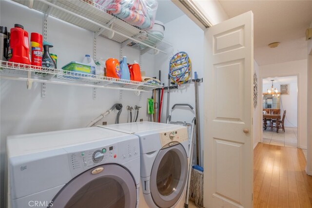 5111 W W Ave M2, Lancaster, CA 93536 - clothes washing area featuring washing machine and clothes dryer, a chandelier, and light wood-style flooring