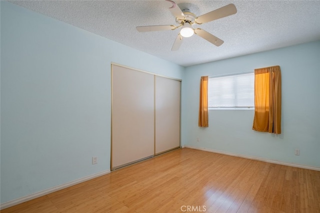 5111 W W Ave M2, Lancaster, CA 93536 - unfurnished bedroom featuring wood finished floors, a textured ceiling, a closet, baseboards, and ceiling fan