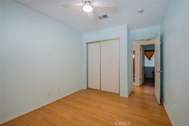 5111 W W Ave M2, Lancaster, CA 93536 - unfurnished bedroom featuring light wood-style floors, a closet, baseboards, and a ceiling fan