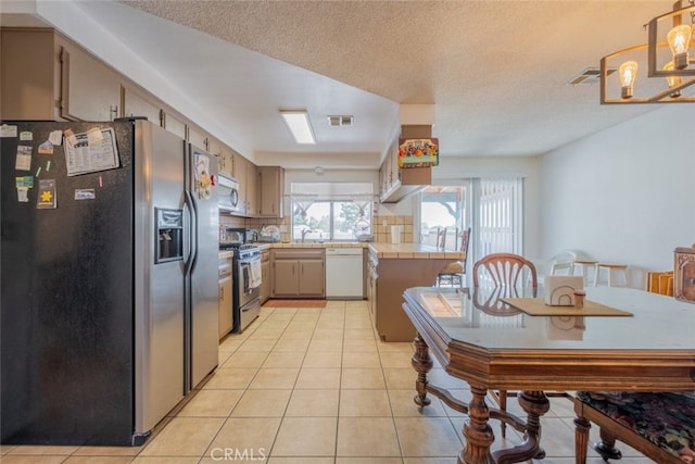 5111 W W Ave M2, Lancaster, CA 93536 - kitchen featuring stainless steel appliances, tile counters, tasteful backsplash, a sink, and light tile patterned floors