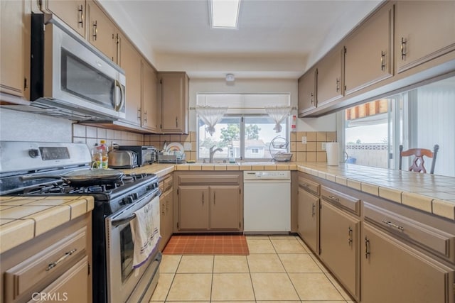 5111 W W Ave M2, Lancaster, CA 93536 - kitchen with stainless steel appliances, healthy amount of natural light, decorative backsplash, and light tile patterned floors