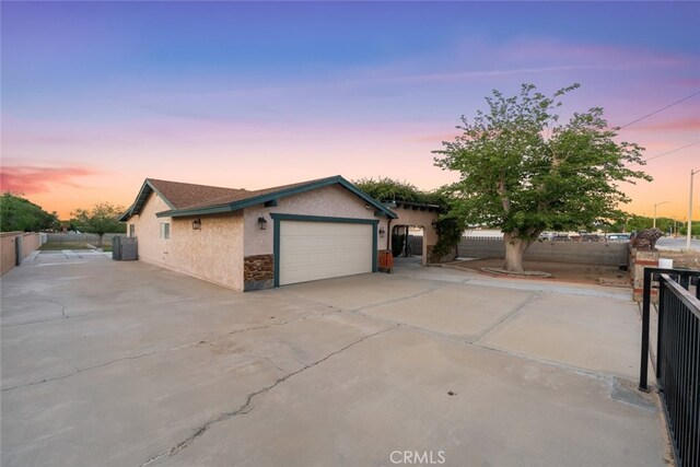 5111 W W Ave M2, Lancaster, CA 93536 - view of front of property featuring driveway, stucco siding, fence, and an attached garage