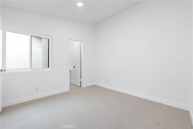 unfurnished room with baseboards, recessed lighting, and light colored carpet