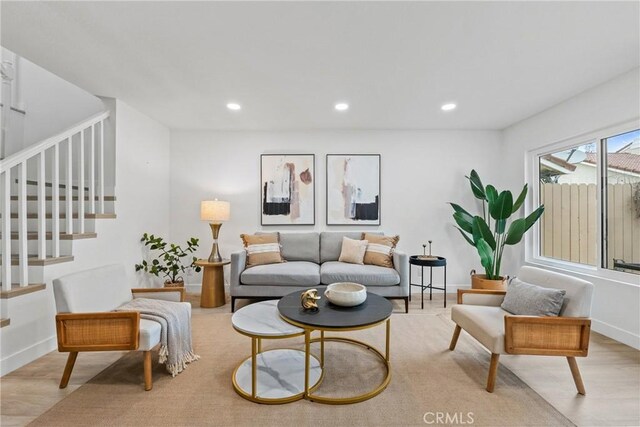 living room with recessed lighting, wood finished floors, and stairs