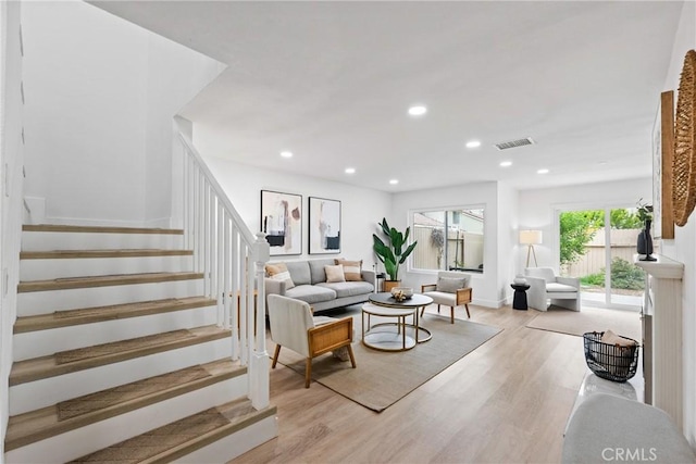 living area featuring stairway, light wood finished floors, baseboards, visible vents, and recessed lighting