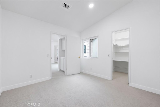 unfurnished bedroom featuring vaulted ceiling, visible vents, carpet flooring, and baseboards