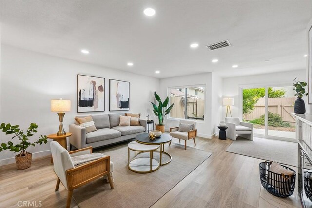 living area featuring recessed lighting, light wood-style flooring, visible vents, and baseboards