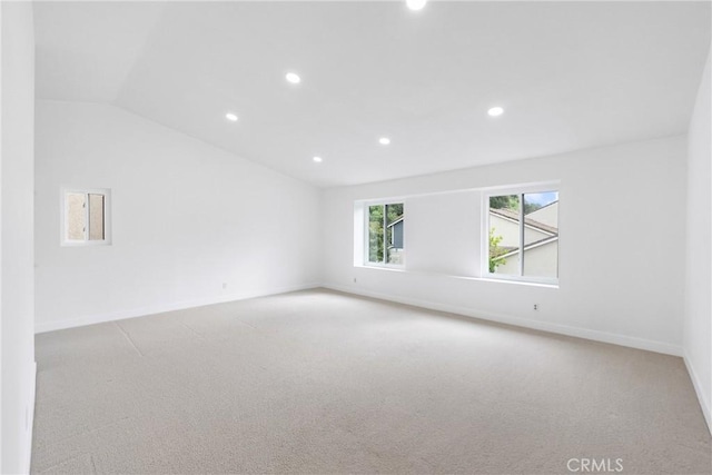 carpeted spare room with recessed lighting, vaulted ceiling, and baseboards