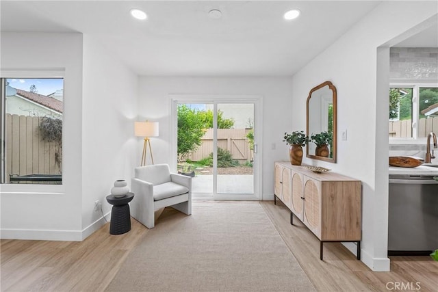 living area featuring light wood finished floors, baseboards, and recessed lighting