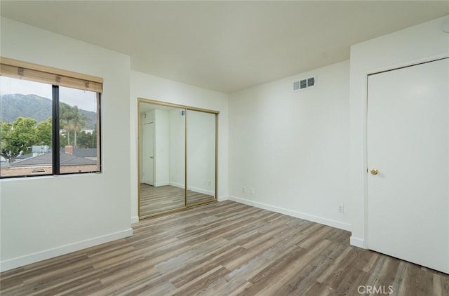527 E Elmwood Ave Unit E, Burbank, CA 91501 - unfurnished bedroom featuring a mountain view, visible vents, wood finished floors, and baseboards