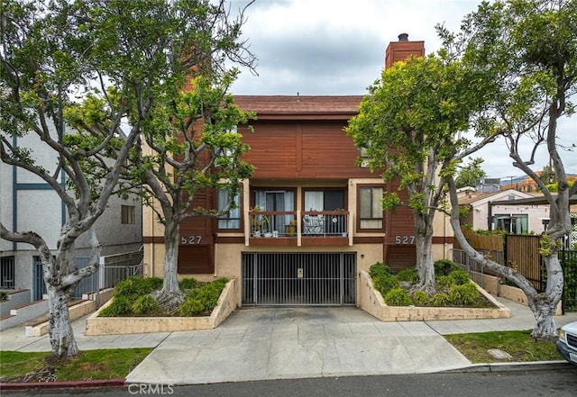 527 E Elmwood Ave Unit E, Burbank, CA 91501 - view of building exterior featuring driveway, a garage, and fence