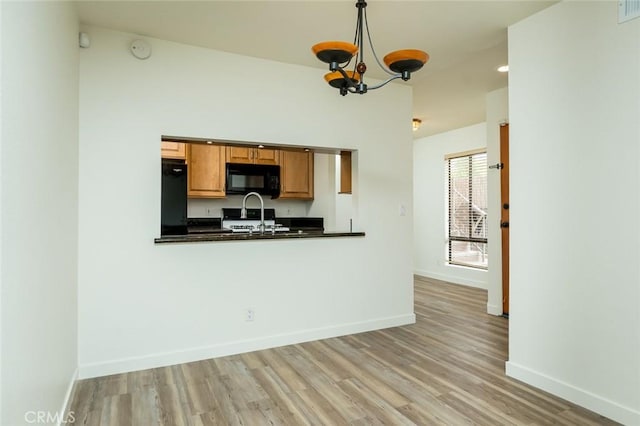 527 E Elmwood Ave Unit E, Burbank, CA 91501 - kitchen featuring a notable chandelier, black microwave, dark countertops, light wood-type flooring, and refrigerator