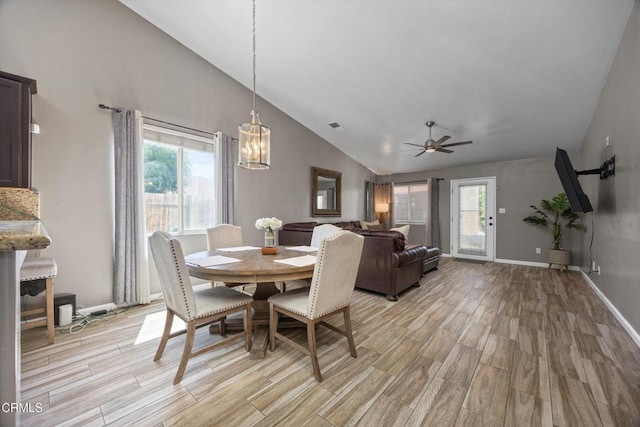 dining space featuring ceiling fan with notable chandelier, baseboards, light wood-style floors, and a healthy amount of sunlight
