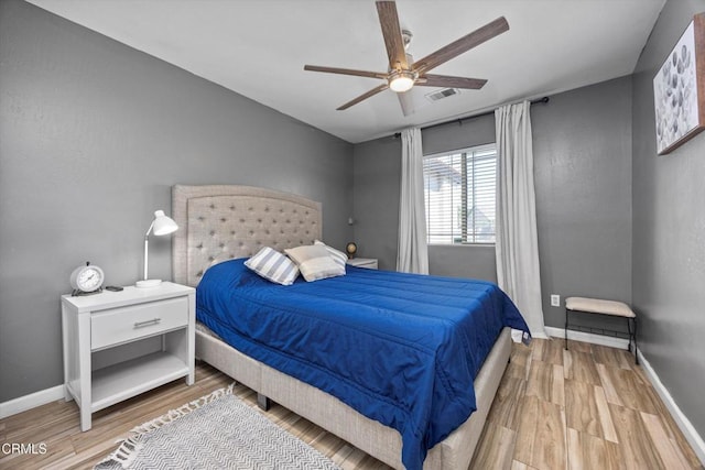 bedroom featuring wood finished floors, visible vents, and baseboards