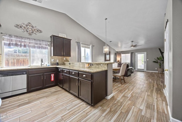 kitchen with a peninsula, stainless steel dishwasher, a sink, dark brown cabinetry, and lofted ceiling