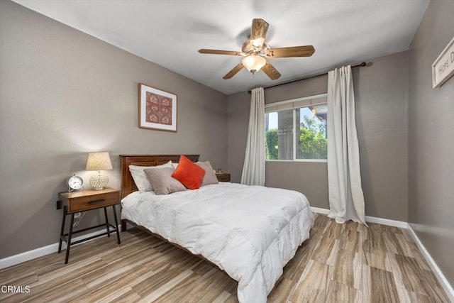 bedroom with baseboards, a ceiling fan, and light wood finished floors