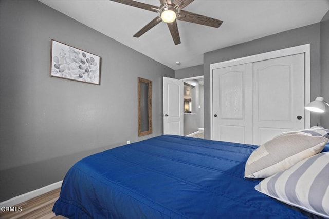 bedroom featuring wood finished floors, a closet, baseboards, and ceiling fan