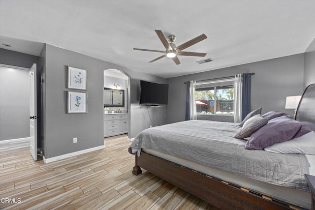 bedroom with light wood-style flooring, ensuite bathroom, baseboards, visible vents, and ceiling fan