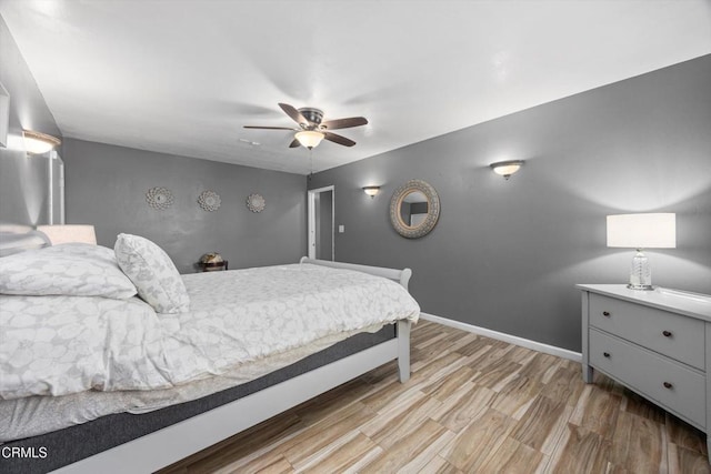 bedroom with ceiling fan, baseboards, and wood finished floors