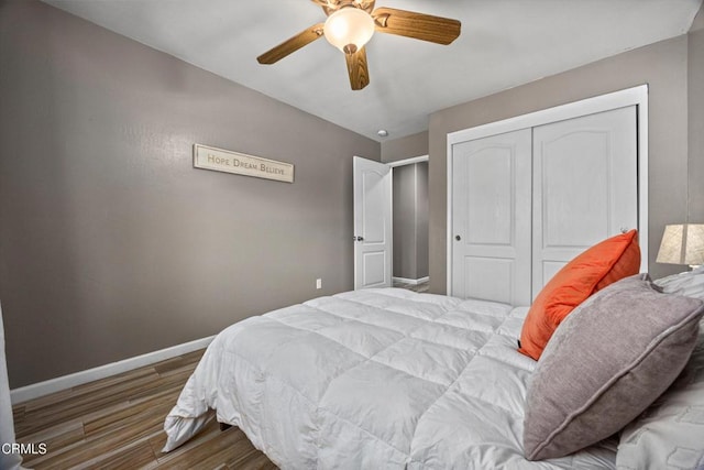 bedroom with ceiling fan, baseboards, wood finished floors, and a closet