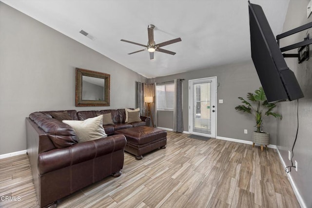 living area featuring lofted ceiling, visible vents, light wood-type flooring, baseboards, and ceiling fan