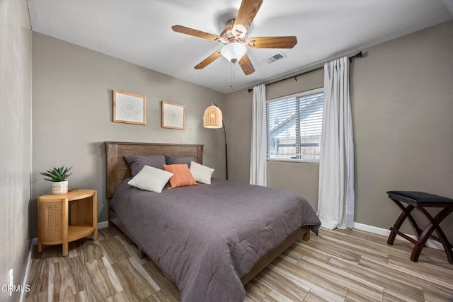 bedroom with visible vents, light wood finished floors, baseboards, and a ceiling fan