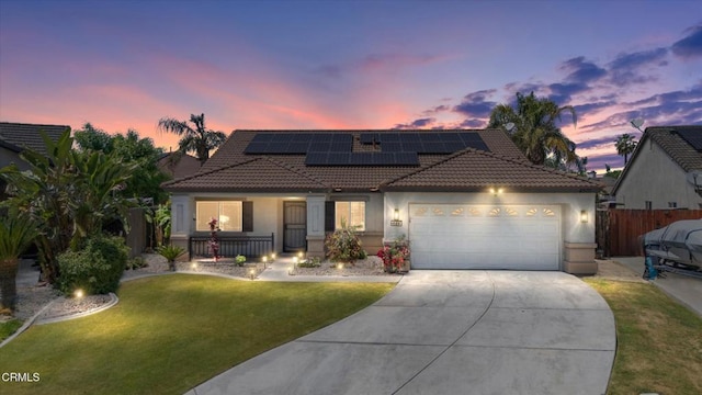 view of front of house with concrete driveway, a tile roof, covered porch, a front yard, and a garage
