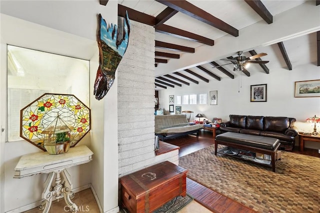 living area with wood finished floors, a ceiling fan, and vaulted ceiling with beams