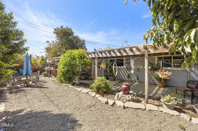back of house featuring a pergola, a patio area, and fence