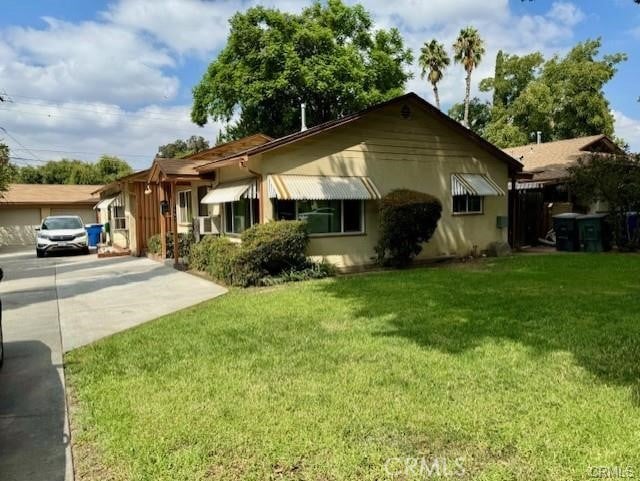 view of front of property with a front lawn, stucco siding, and driveway