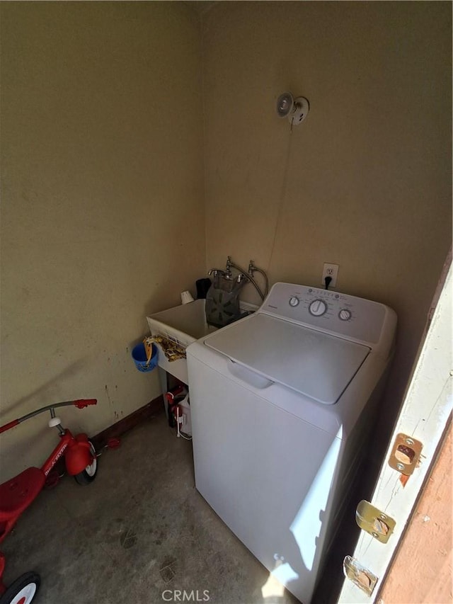 washroom featuring laundry area, a sink, and washer / dryer