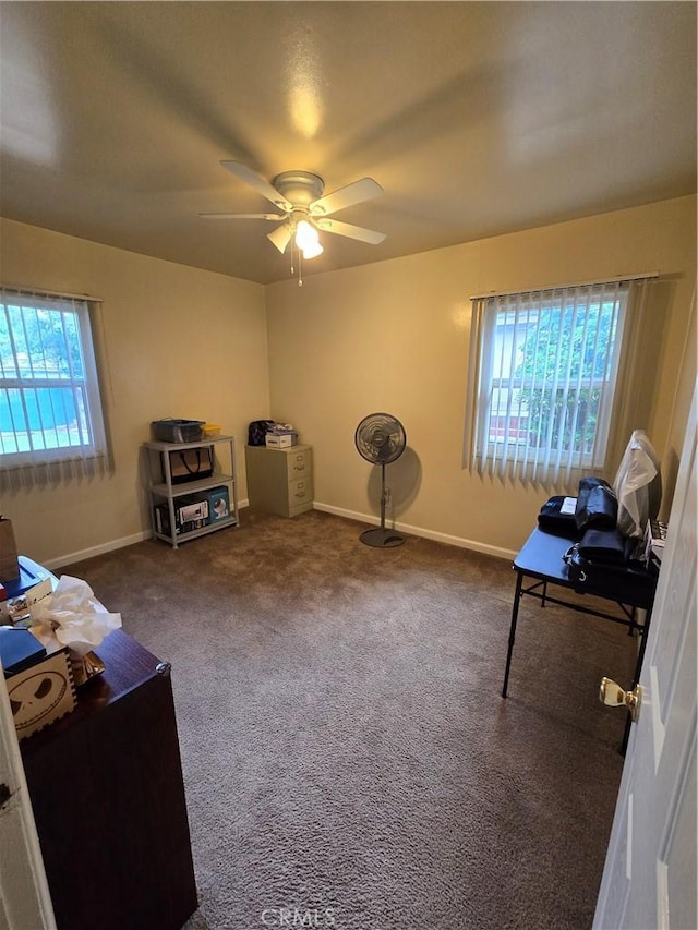 interior space featuring baseboards, a ceiling fan, and carpet