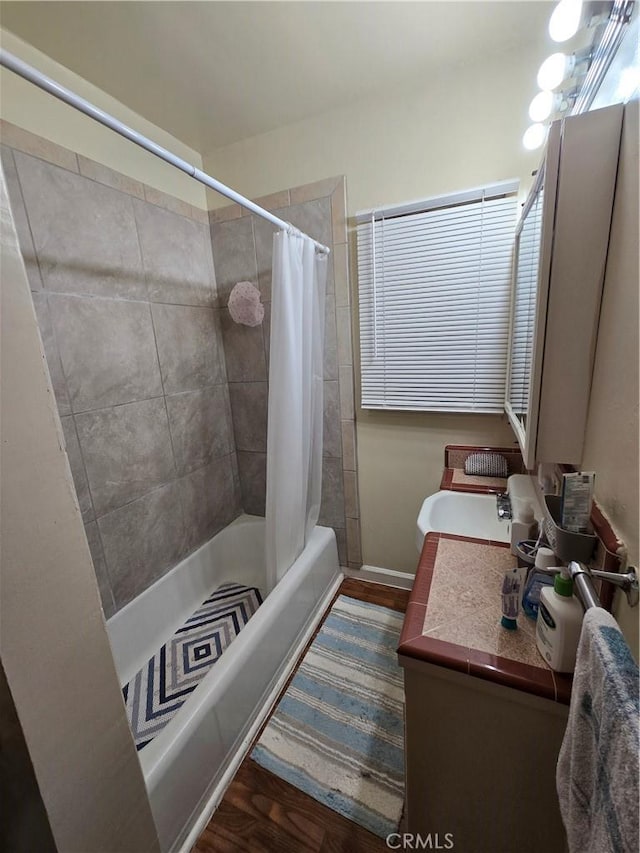 bathroom featuring vanity, baseboards, and shower / bath combination with curtain
