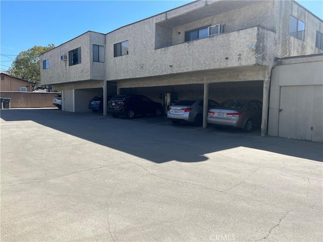 view of side of property featuring covered parking and stucco siding