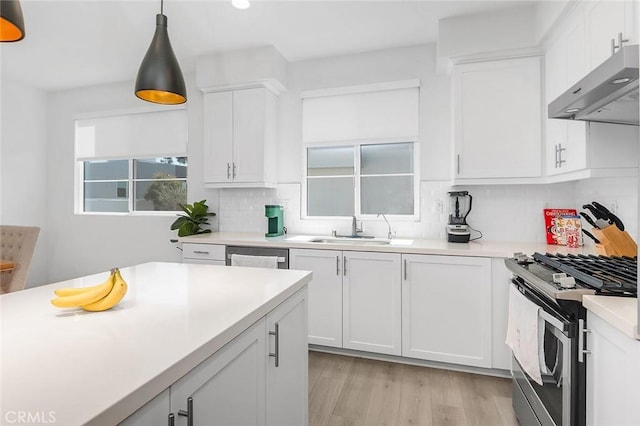 208 Novel, Irvine, CA 92618 - kitchen with under cabinet range hood, appliances with stainless steel finishes, tasteful backsplash, white cabinetry, and light countertops