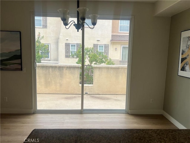 44936 Honey Locust Dr, Temecula, CA 92592 - unfurnished dining area featuring an inviting chandelier, a wealth of natural light, wood finished floors, and baseboards