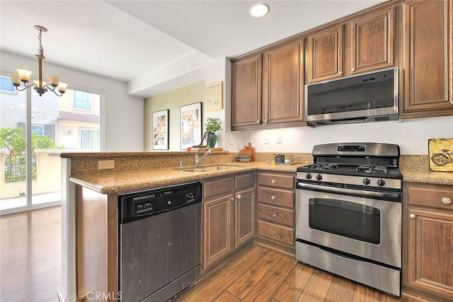 44936 Honey Locust Dr, Temecula, CA 92592 - kitchen with dark wood-style floors, an inviting chandelier, a sink, a peninsula, and appliances with stainless steel finishes