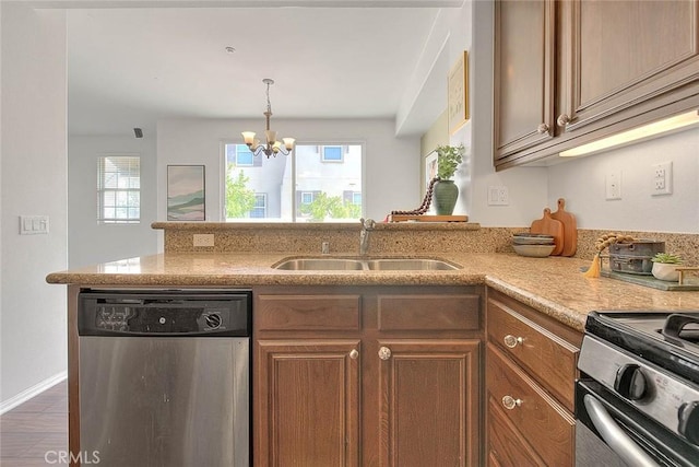 44936 Honey Locust Dr, Temecula, CA 92592 - kitchen featuring a sink, brown cabinets, a notable chandelier, a peninsula, and stainless steel dishwasher
