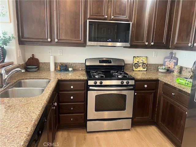 44936 Honey Locust Dr, Temecula, CA 92592 - kitchen featuring stainless steel appliances, dark brown cabinets, light wood-style flooring, and a sink