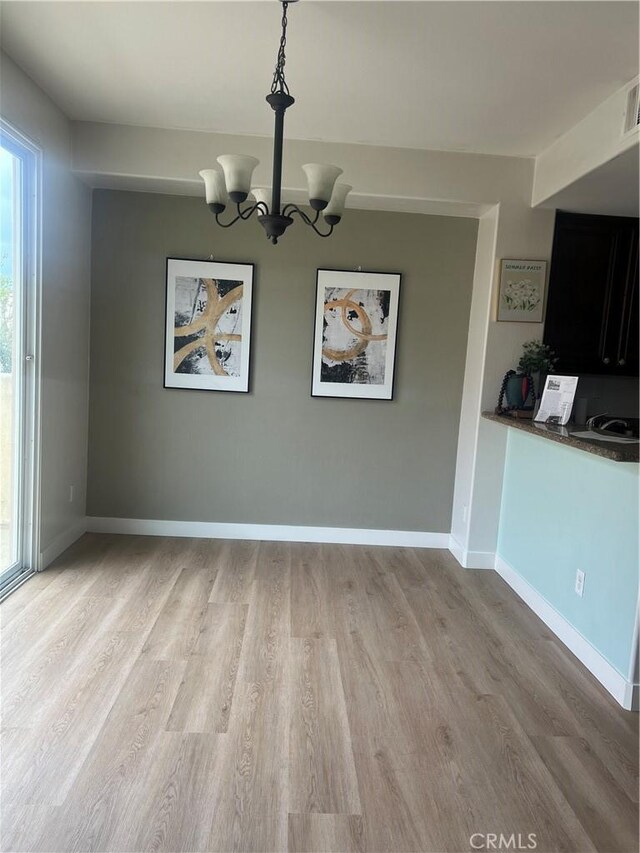 44936 Honey Locust Dr, Temecula, CA 92592 - unfurnished dining area with baseboards, wood finished floors, an inviting chandelier, and plenty of natural light