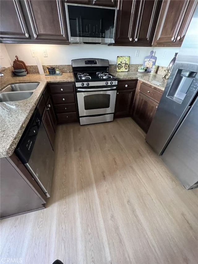 44936 Honey Locust Dr, Temecula, CA 92592 - kitchen featuring a sink, light wood-type flooring, dark brown cabinetry, light stone counters, and appliances with stainless steel finishes