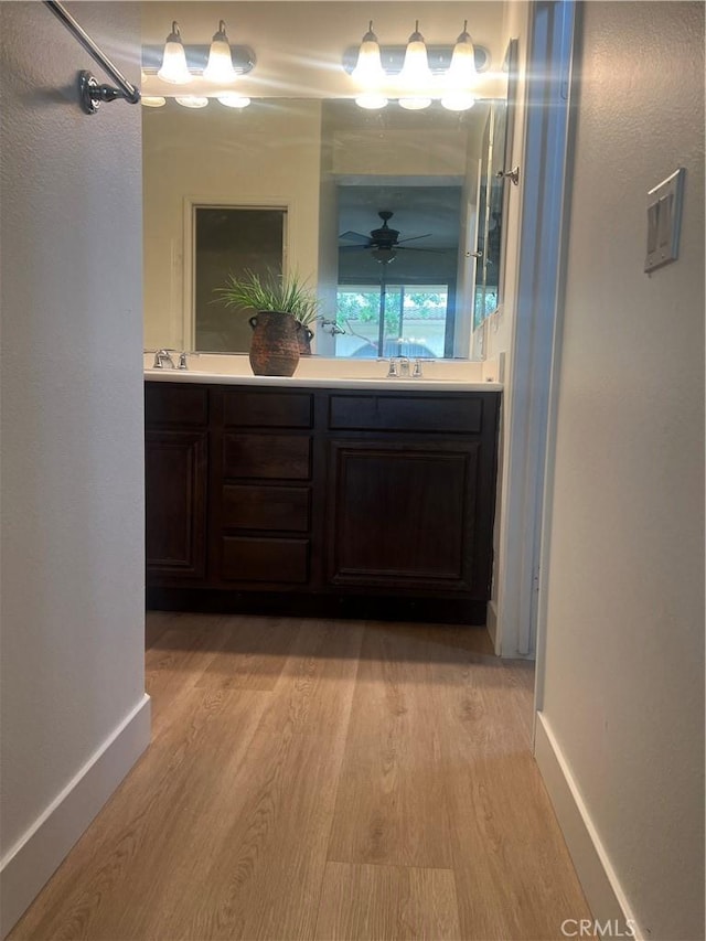 44936 Honey Locust Dr, Temecula, CA 92592 - bathroom featuring a sink, double vanity, wood finished floors, and baseboards