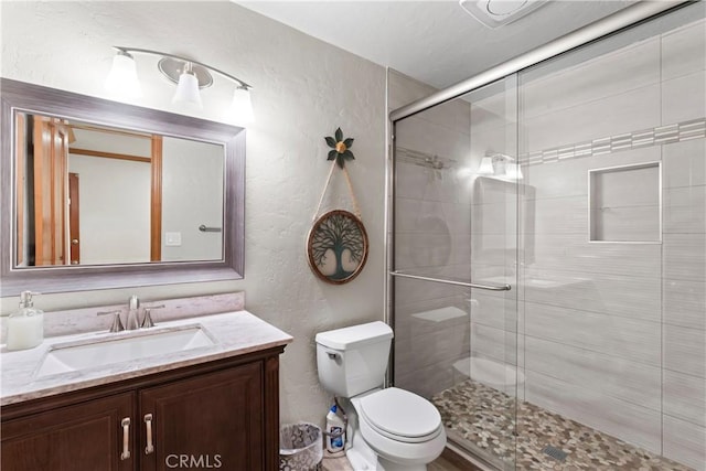 27363 Matterhorn Dr, Lake Arrowhead, CA 92352 - bathroom featuring a textured wall, vanity, a shower stall, and toilet