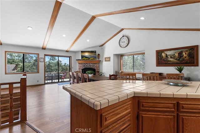27363 Matterhorn Dr, Lake Arrowhead, CA 92352 - kitchen featuring open floor plan, wood finished floors, a brick fireplace, and a wealth of natural light