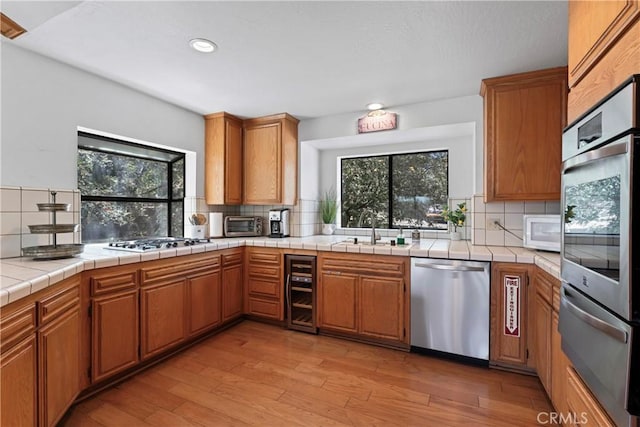 27363 Matterhorn Dr, Lake Arrowhead, CA 92352 - kitchen featuring decorative backsplash, plenty of natural light, beverage cooler, and appliances with stainless steel finishes