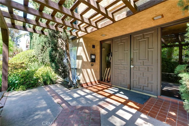 120 S Sierra Madre Blvd Unit 206, Pasadena, CA 91107 - view of exterior entry featuring stucco siding and a pergola
